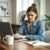 Professional woman reading an email marked “Please report to HR,” with a concerned look.